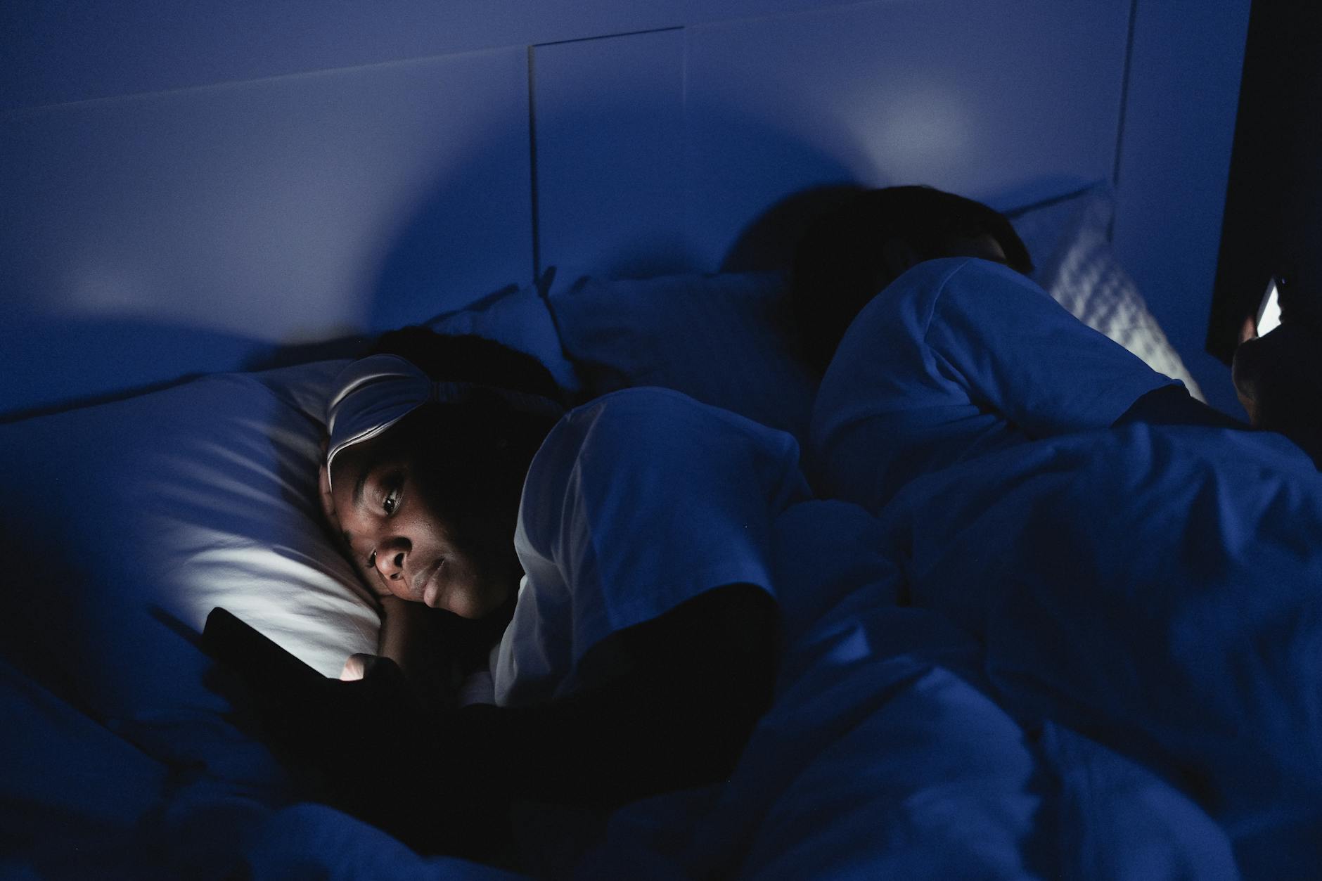 Adult sleeping peacefully in a dark bedroom with optimal sleep environment