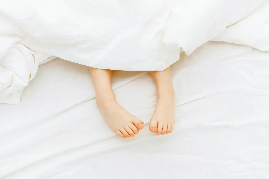 Child sleeping comfortably in bed with cosy duvet