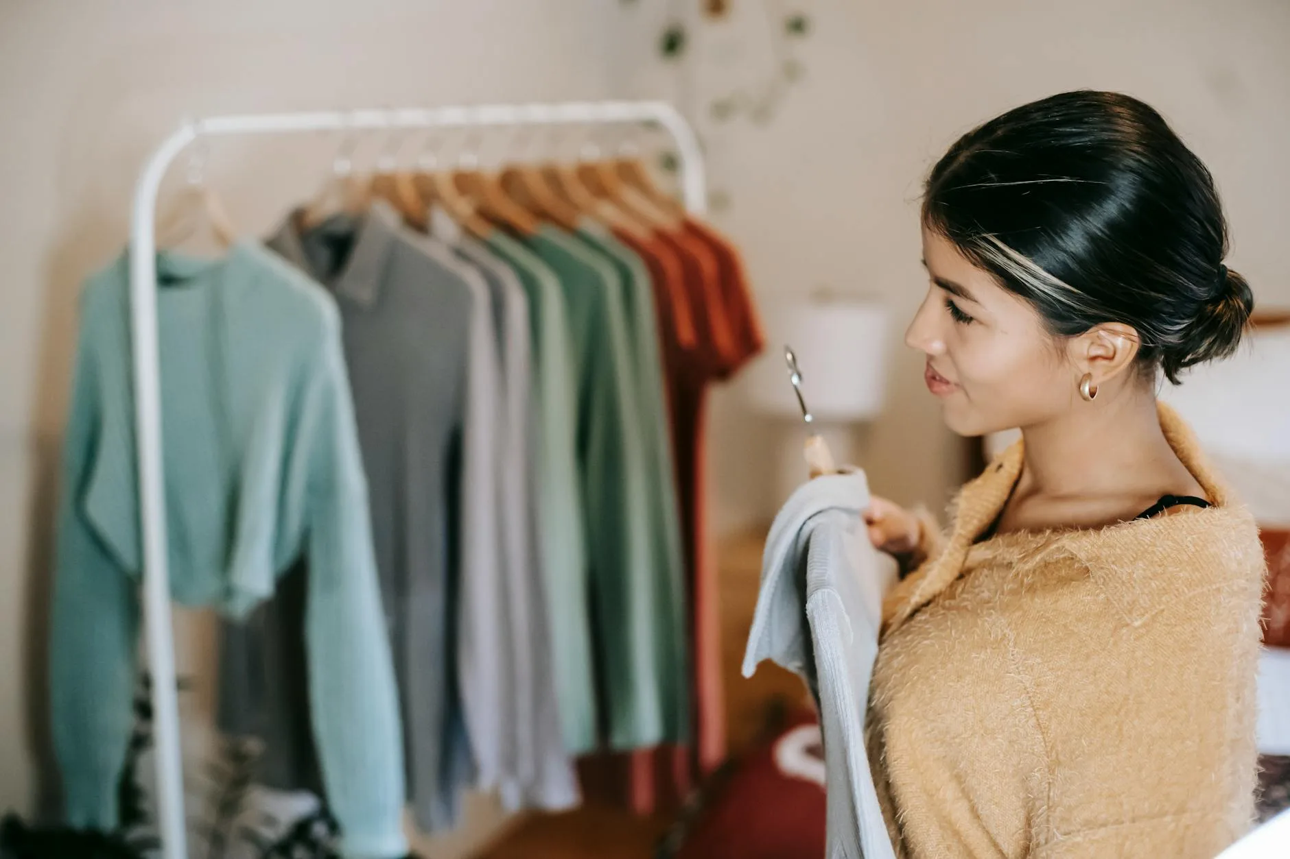 Open clothes rail with neatly hung garments in a bedroom