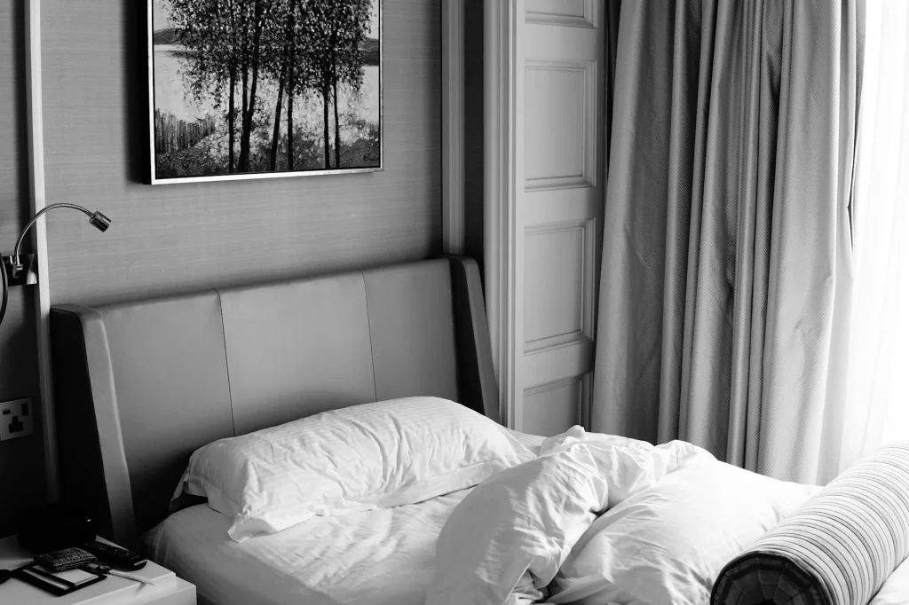 Cosy single bed with white sheets in a bedroom