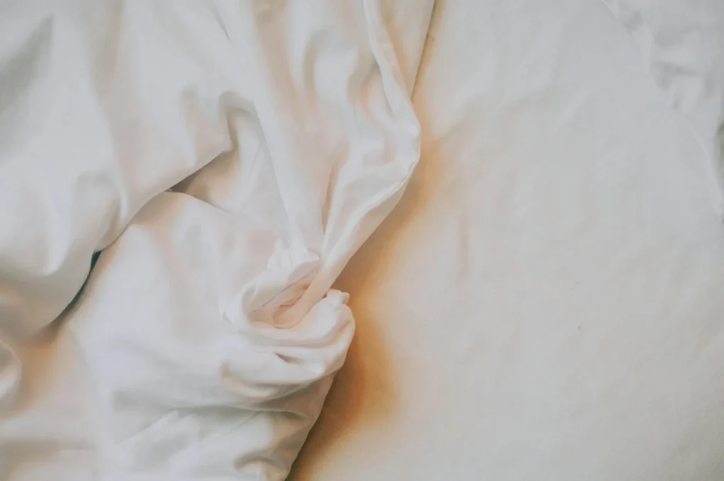 Close up of white cotton bed sheets showing fabric texture