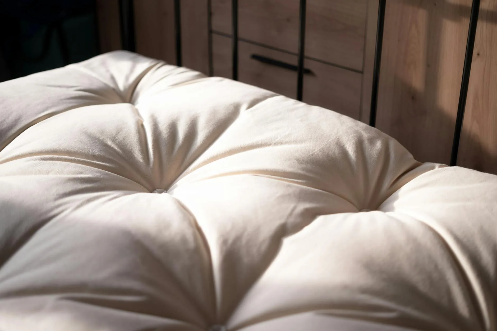 Close-up of a mattress and crisp white bed linen showing the quilted top cover detail