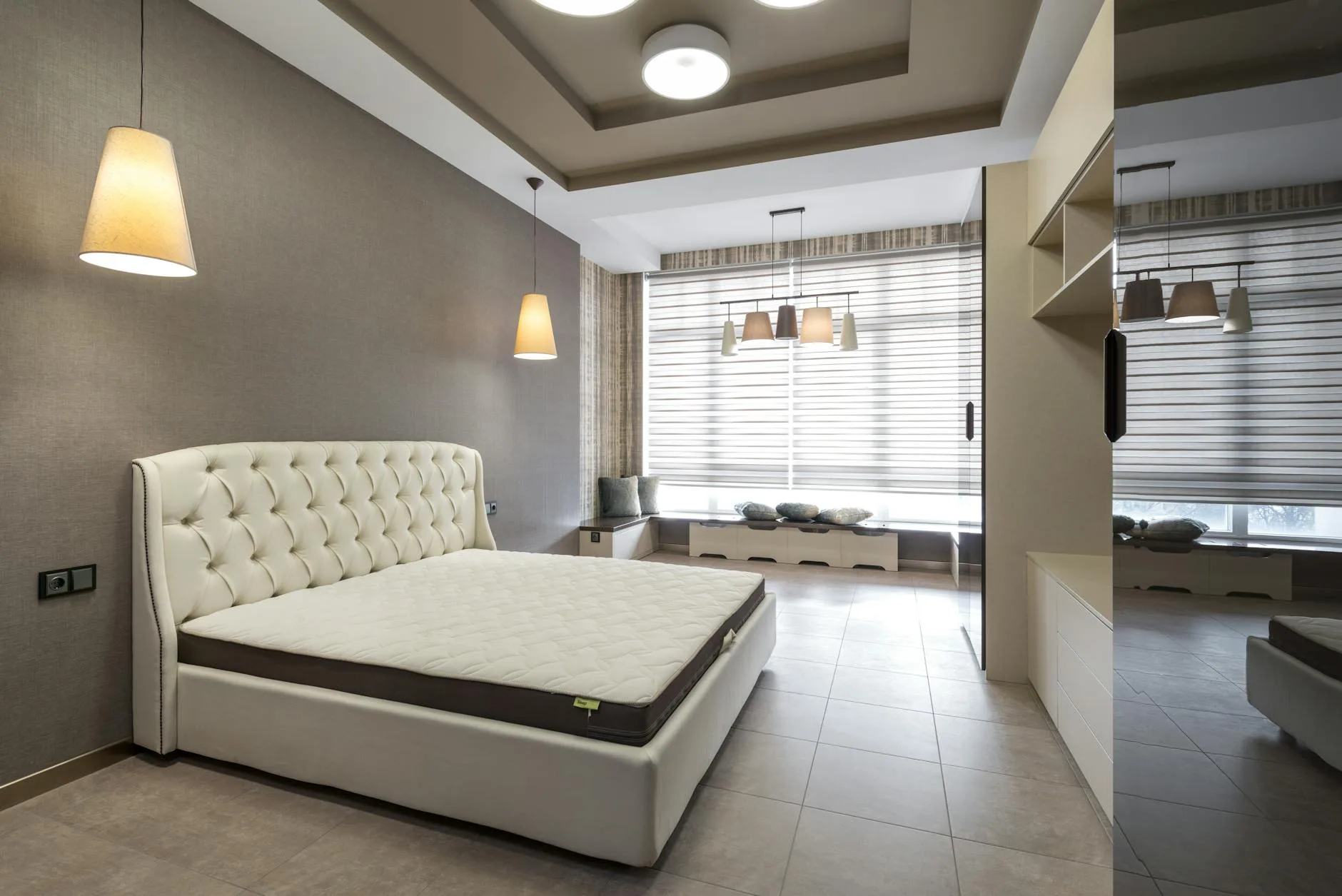 Person testing mattress firmness in a bed showroom