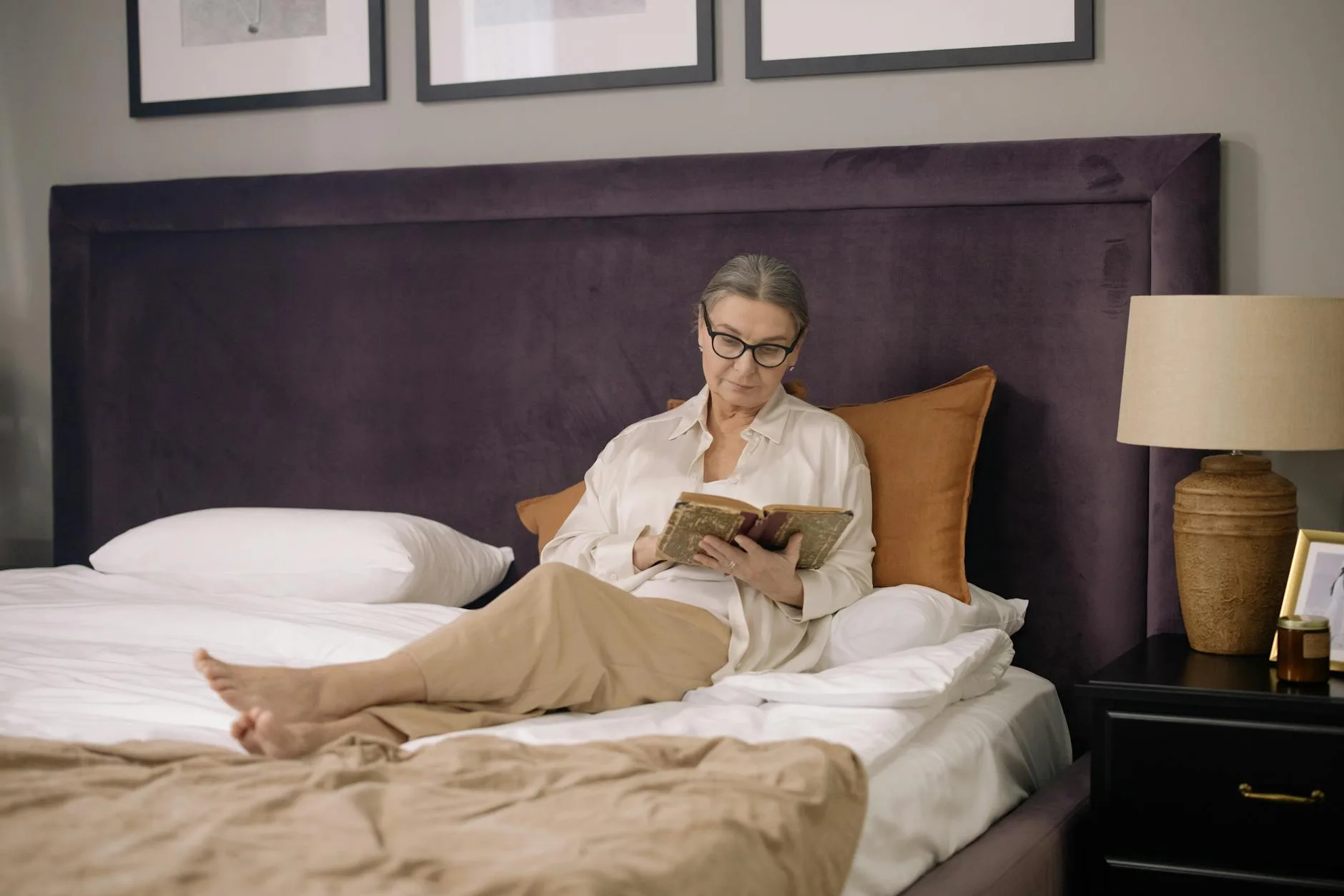Person reading in bed propped up comfortably with pillows