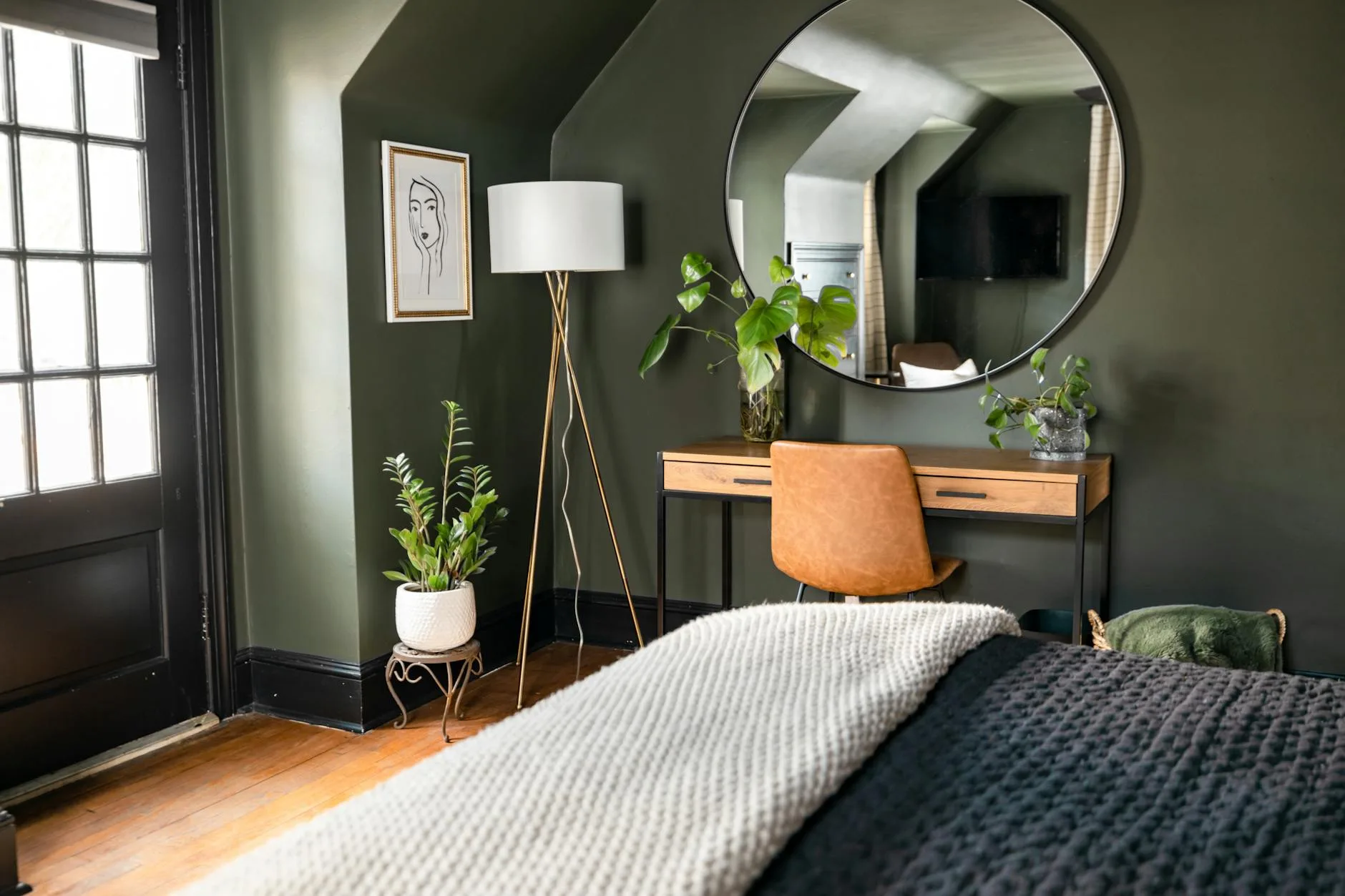 Sage green bedroom walls with modern decor and bed