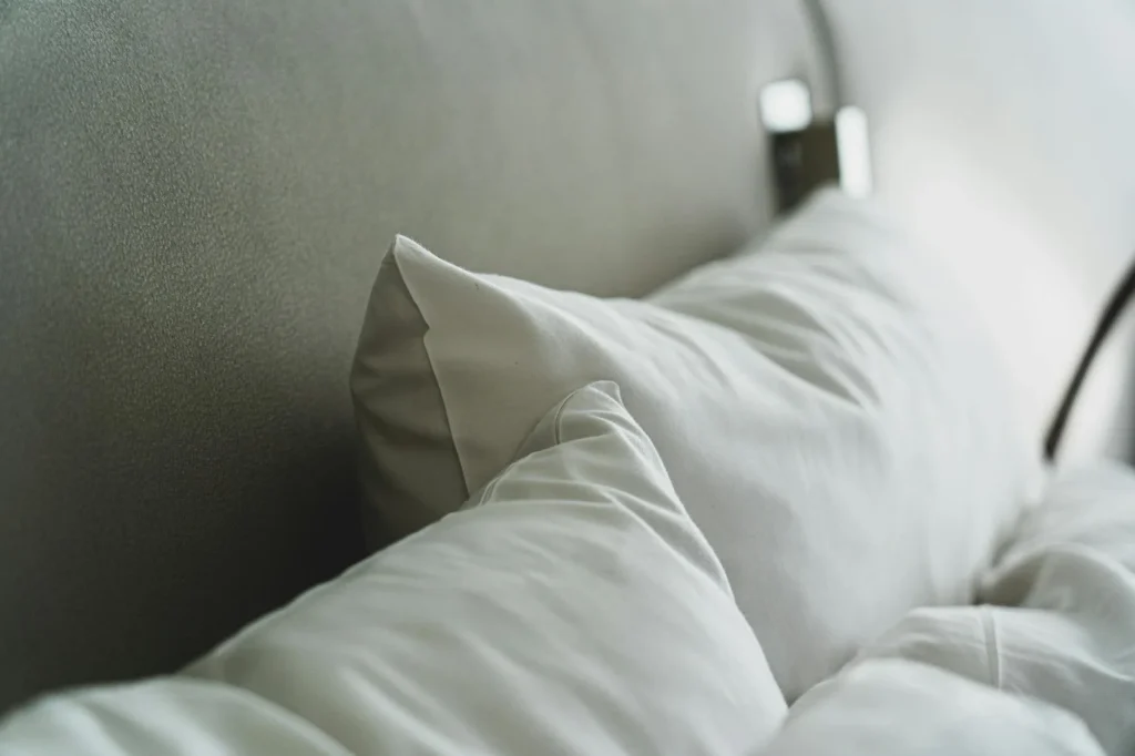 Clean modern bedroom interior with white bedding and pillows