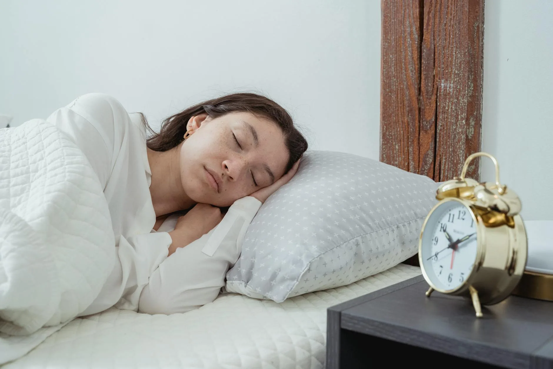 Woman sleeping comfortably in bed with soft morning light