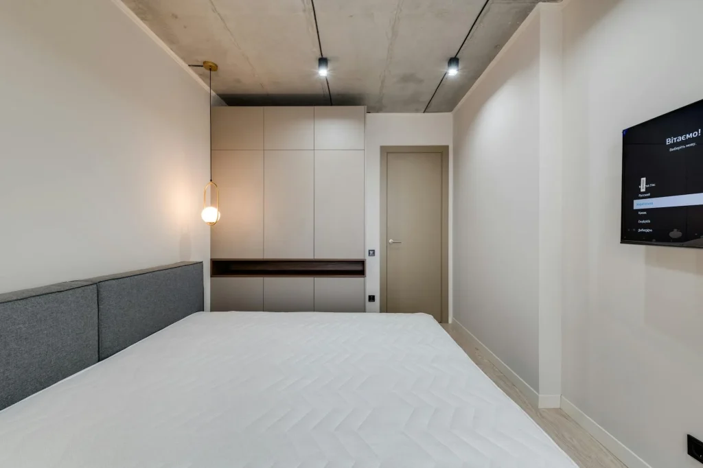 Clean modern mattress on a bed frame in a bright bedroom