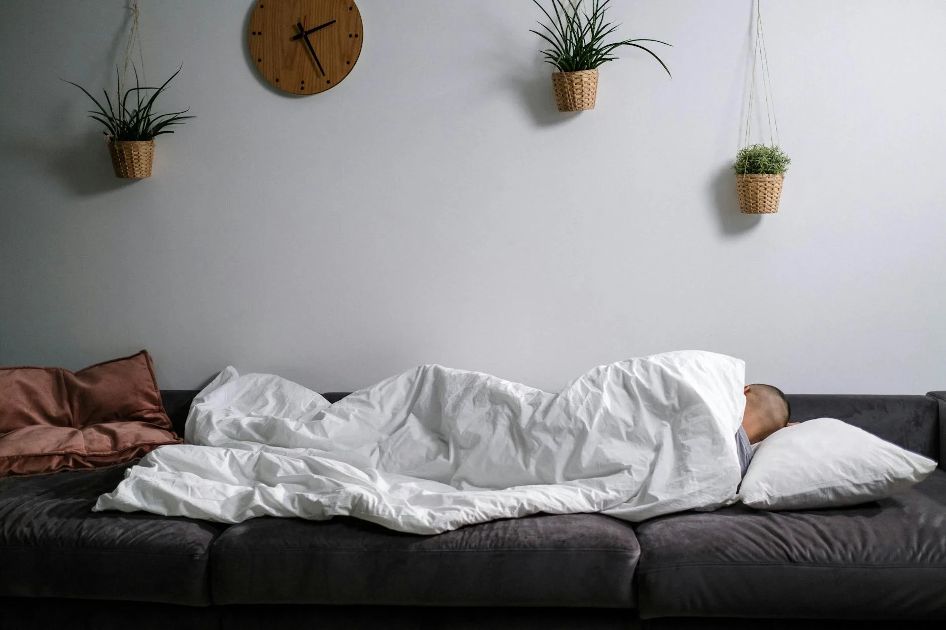 Person relaxing under a blanket on a sofa