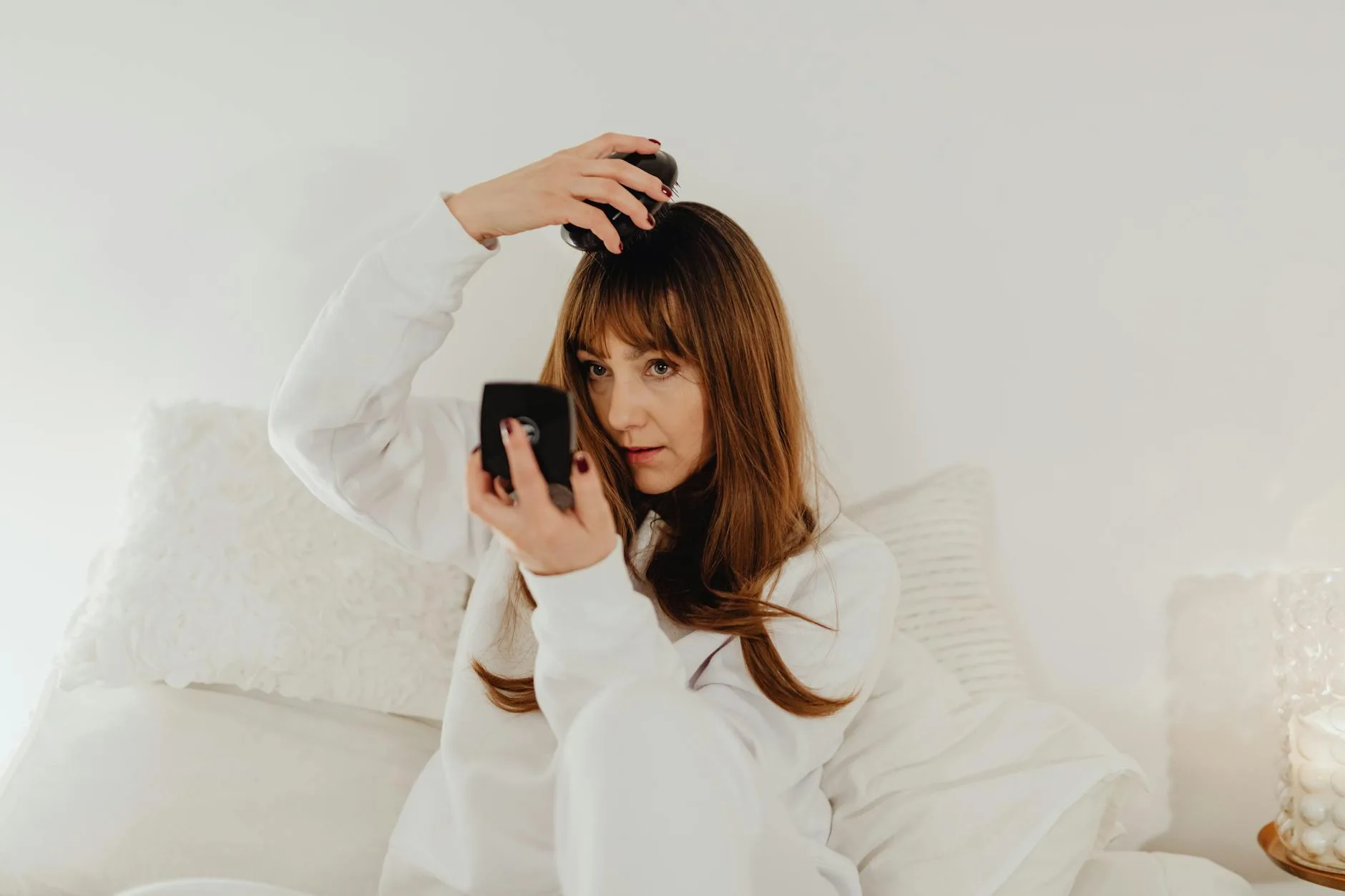 Woman brushing smooth hair in morning sunlight