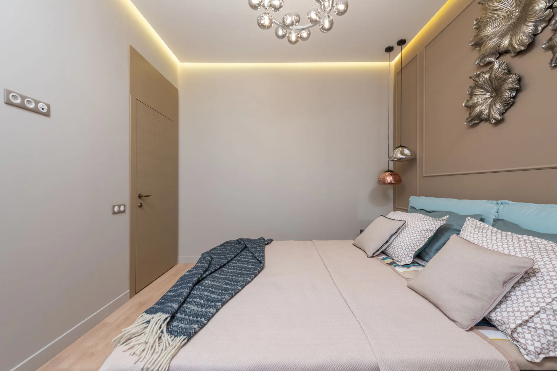 Warm neutral bedroom scheme showing layered bedding and painted walls