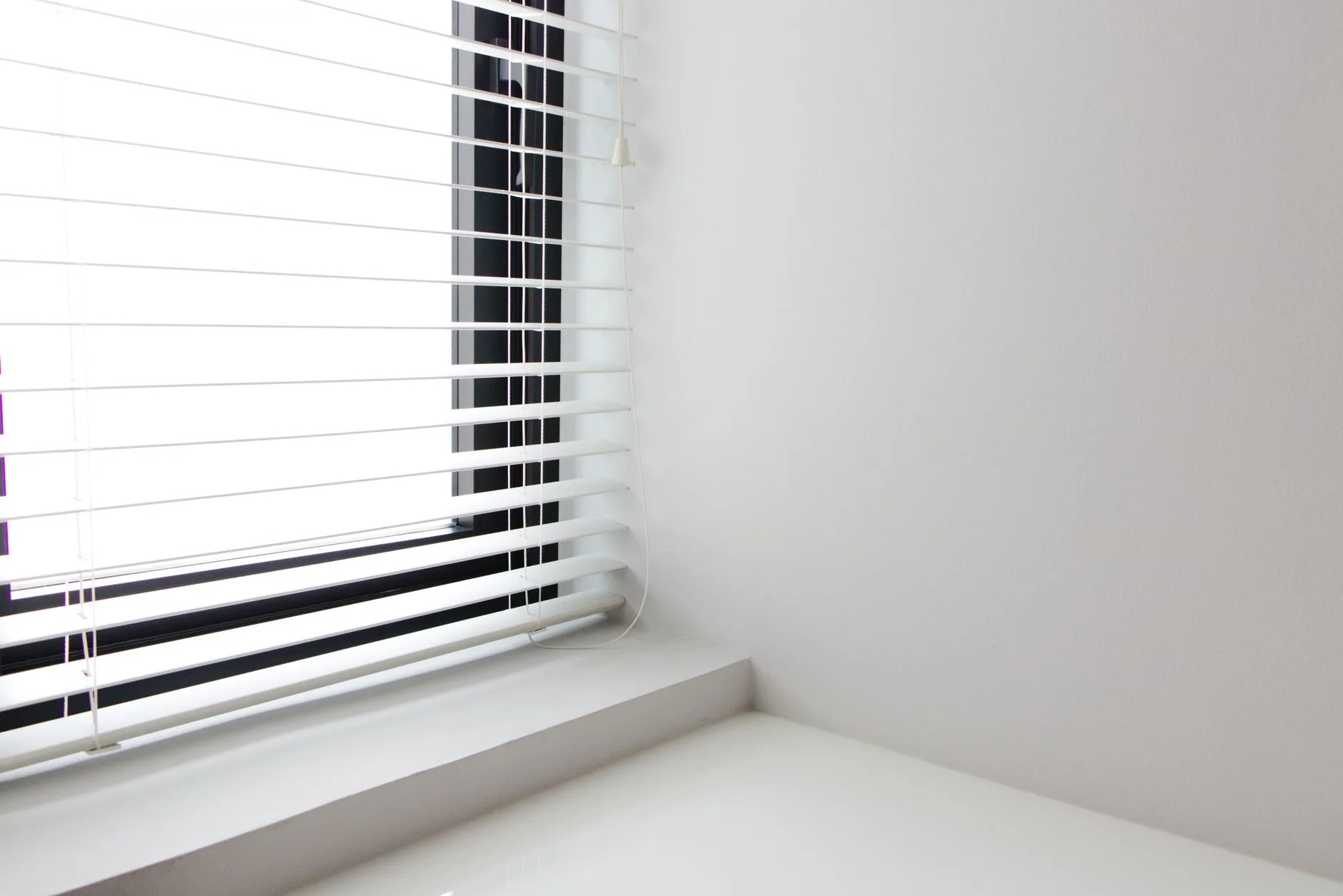 Blind cord hanging beside a bedroom window