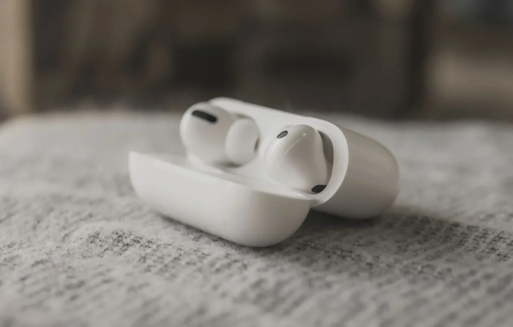 Small wireless sleep earbuds in a charging case beside a bed